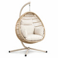 Sillón colgante de mimbre con cojines beige